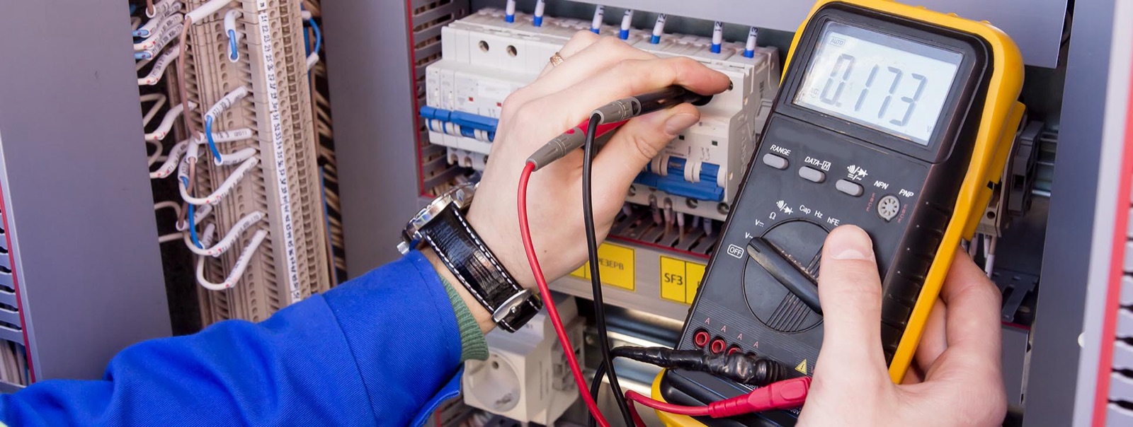 Multimeter reading being taken at a breaker panel